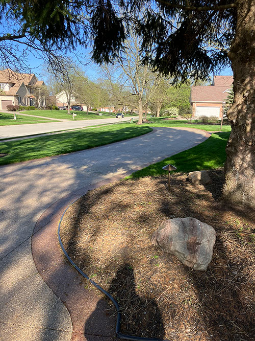 New stained, exposed aggregate concrete driveway with a stained border in Carmel, Indiana.